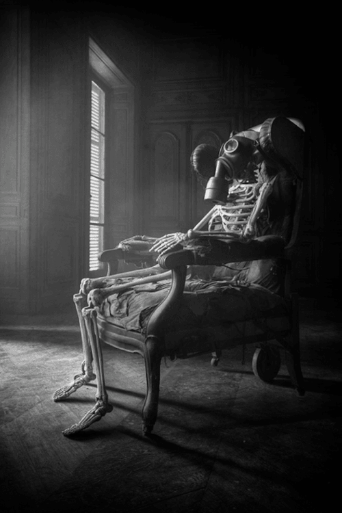 skeleton sitting on chair with air mask.